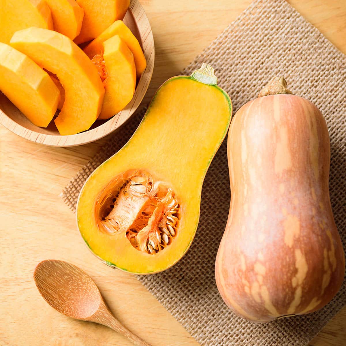 Raw butternut squash - whole, halved, and sliced,