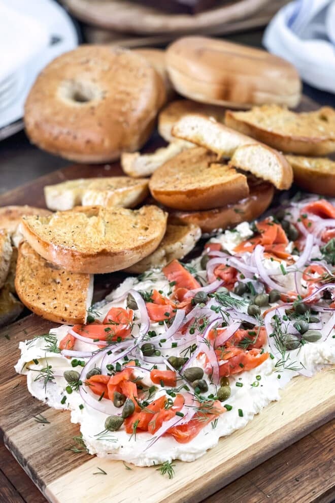Cream cheese board with smoked salmon and onion, and toasted bagels.
