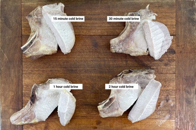 Comparison of pork chops that have been brined for different times, cut and on a wooden board.