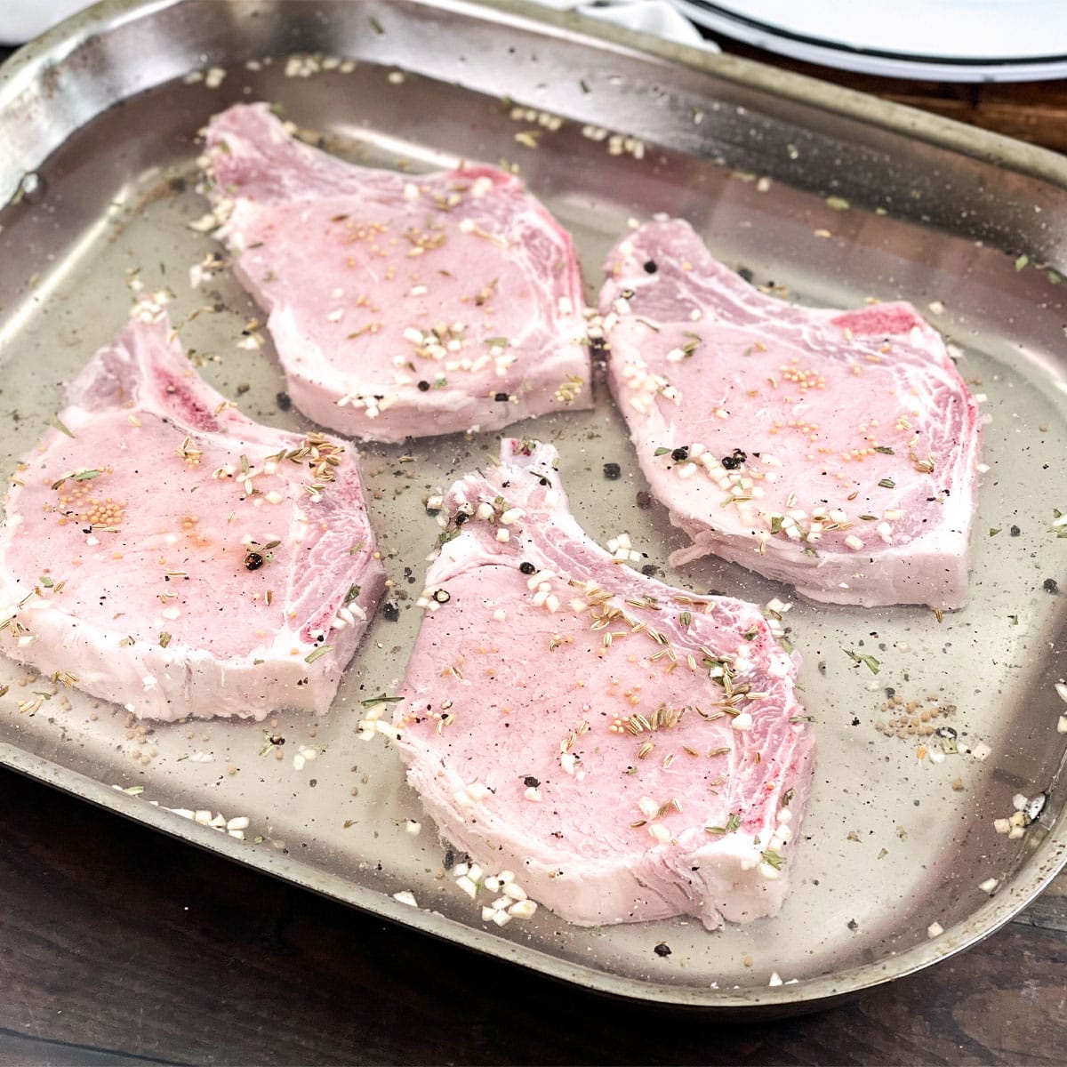 Raw bone-in pork chops in a brine