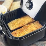 Toasty garlic bread loaves in the air fryer basket.