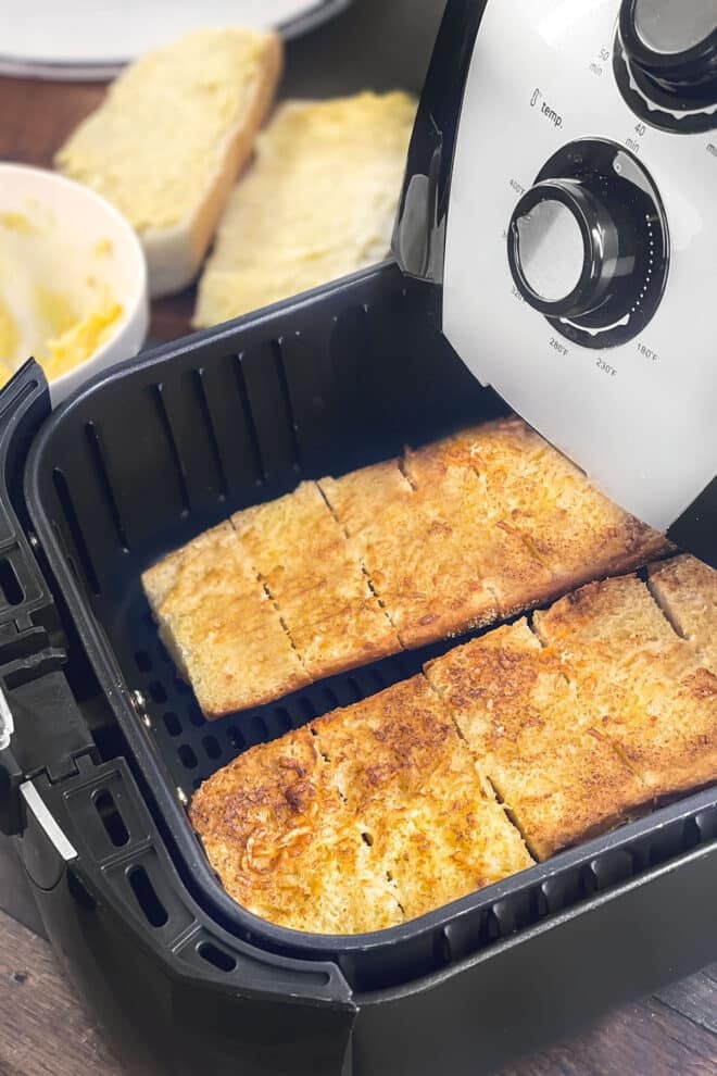Toasty garlic bread loaves in the air fryer basket.