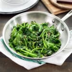 Sauteed garlic mustard greens in a stainless steel pan.