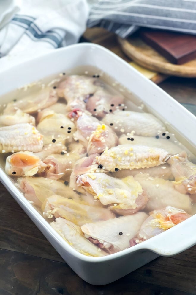 Chicken wings in white dish of brine.