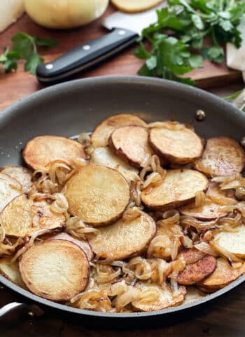 Fried potatoes and onions in a skillet.