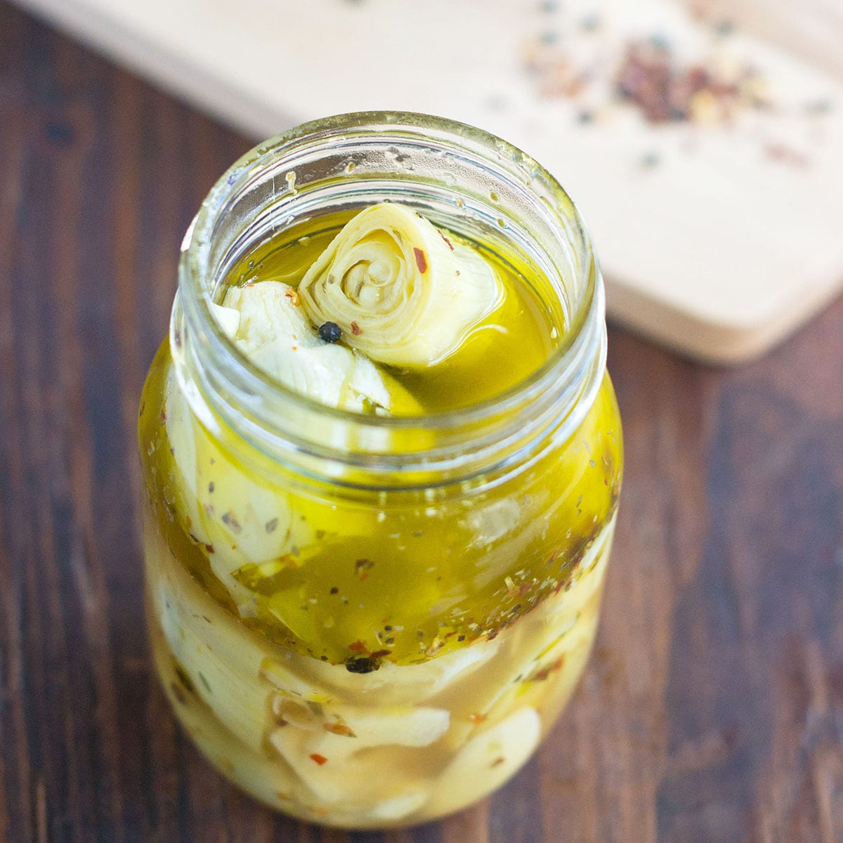 A jar with artichoke hearts in a marinade