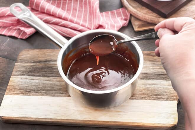 Rich brown espagnole sauce in a saucepan with spoon