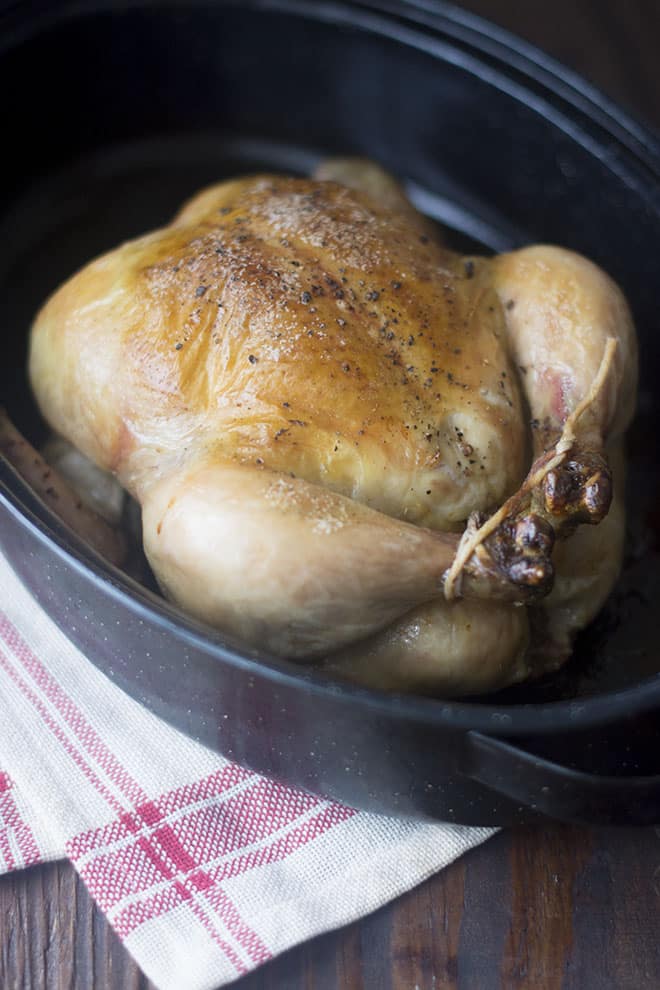Whole roasted chicken in a baking dish.