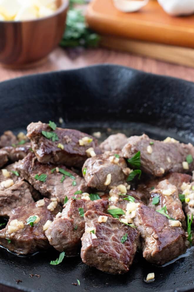 Steak Tips with garlic butter in a cast iron skillet.