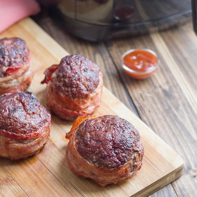 Mini Bacon-Wrapped Meatloaves on a cutting board.