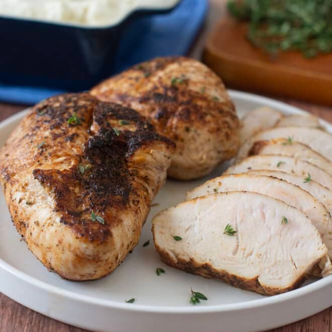 Roasted turkey tenderloins on a plate, one in slices.