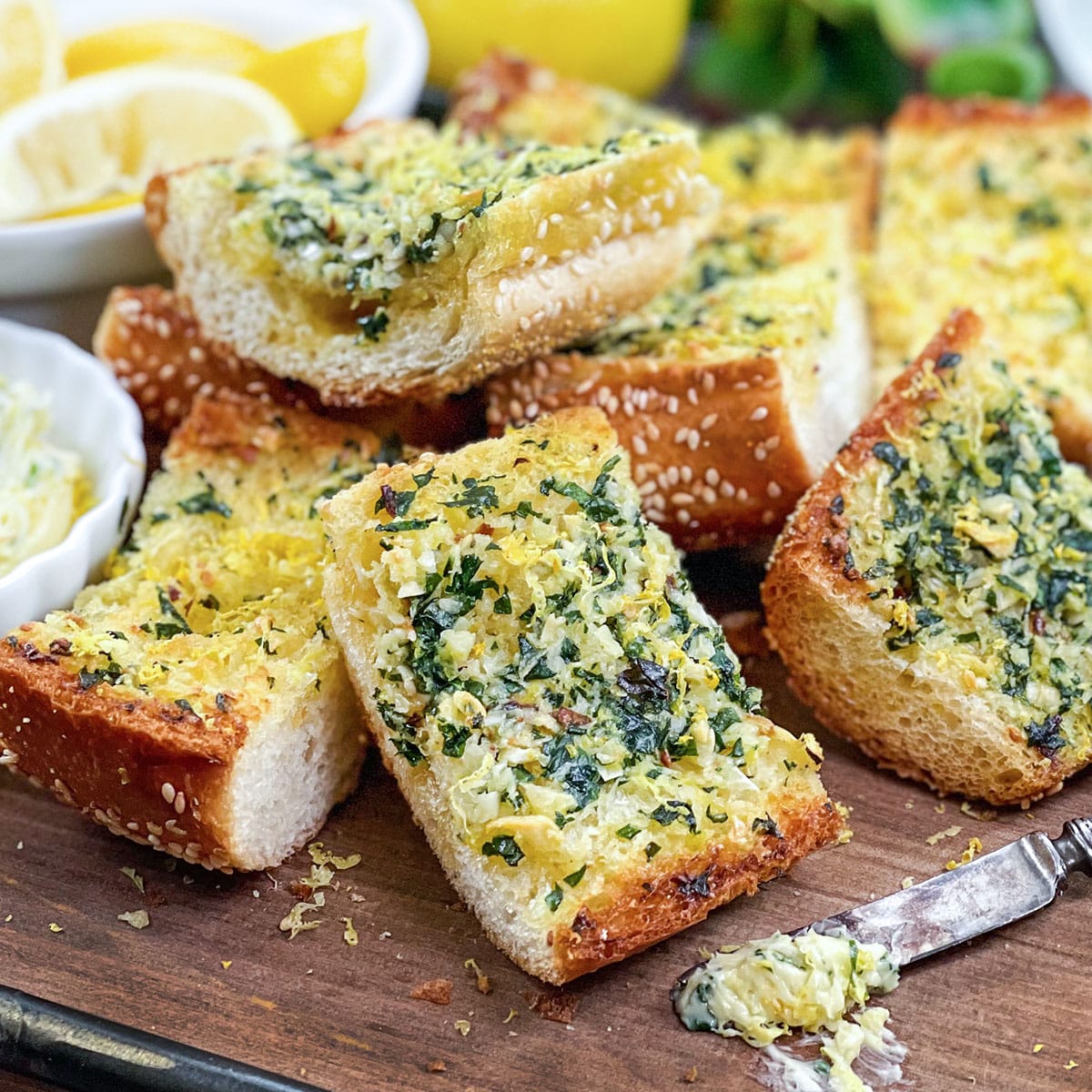 Slices of garlic bread with lemon zest and fresh parsley.
