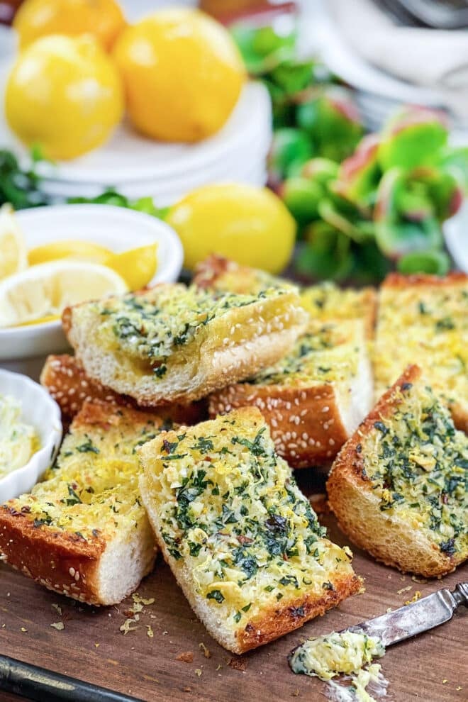 Slices of garlic bread with lemon zest and fresh parsley.