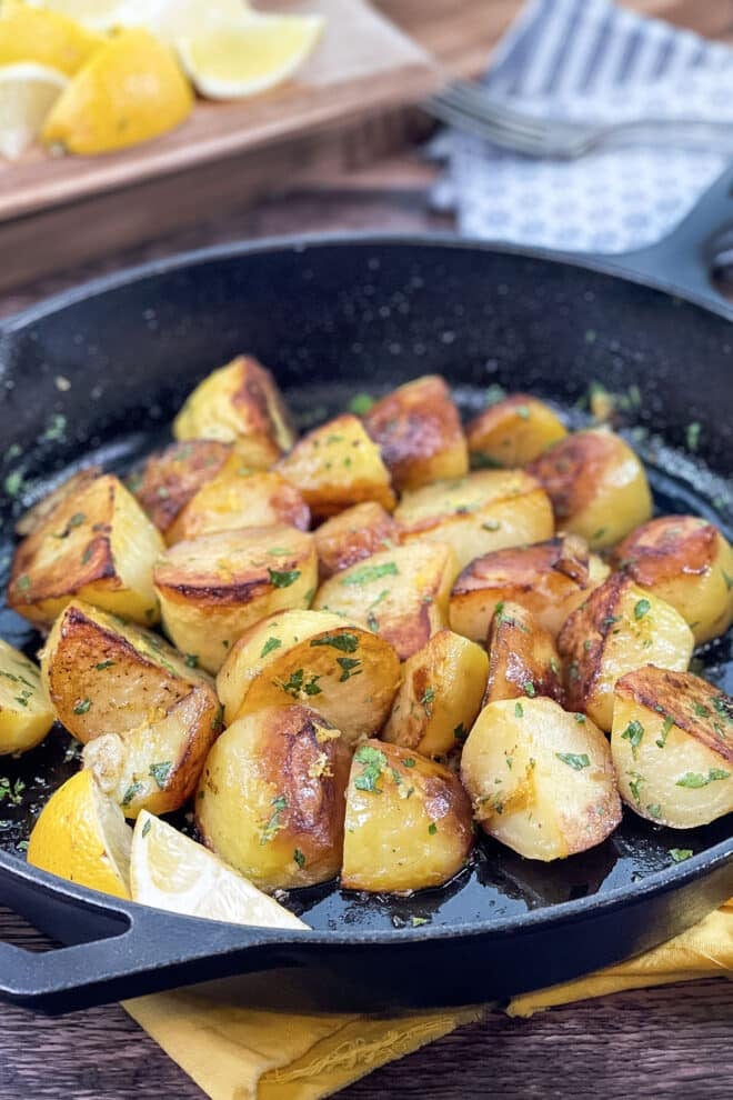 Cast iron pan of browned lemon potatoes.