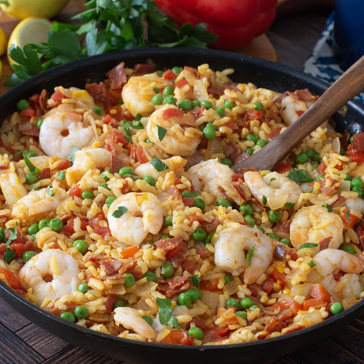 Pan of shrimp paella with peas and parsley.