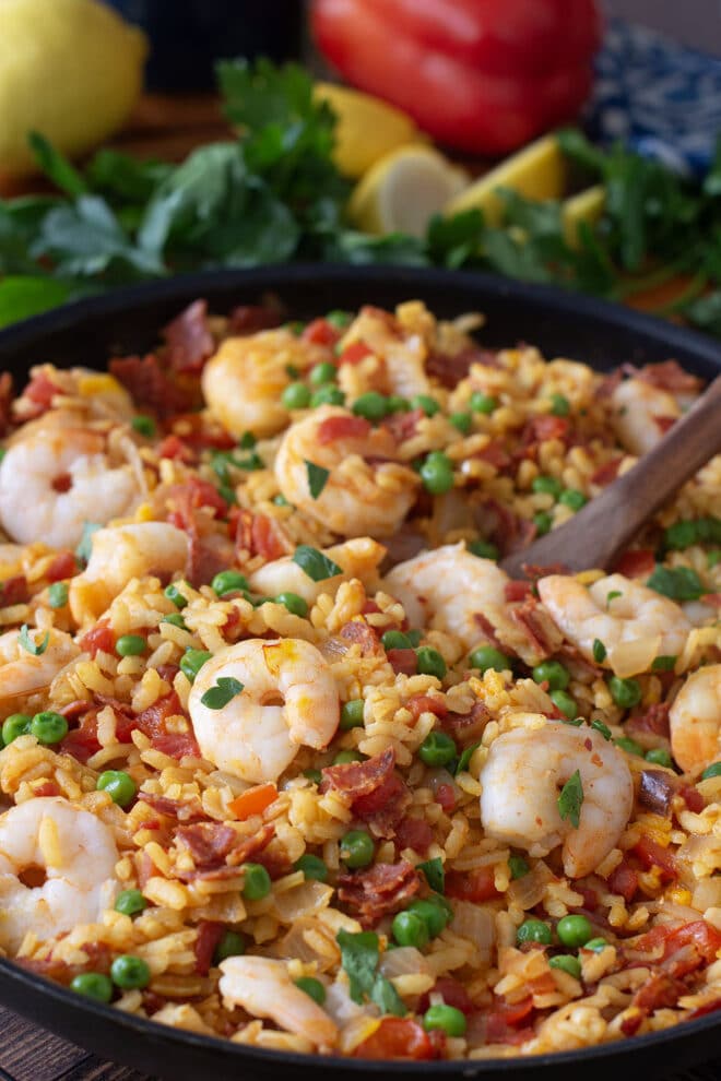 Pan of shrimp paella with peas and parsley.  