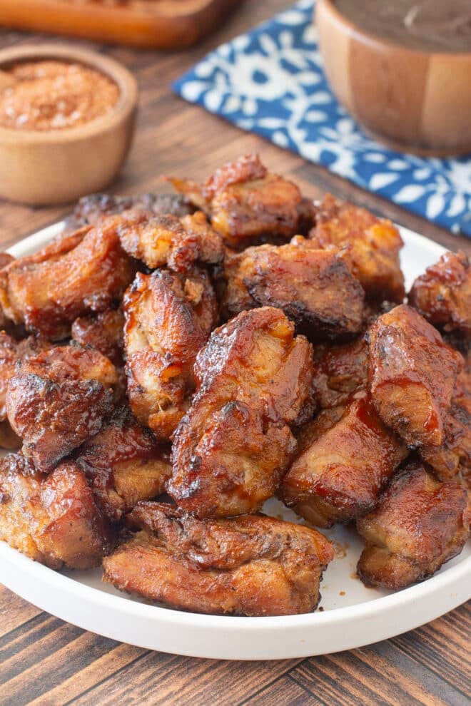 Plate of cooked rib tips with BBQ sauce.