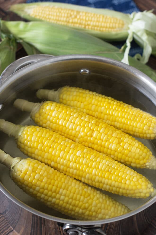 Four ears of corn in a large pot of water.