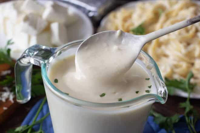 Microwave alfredo sauce in a glass measuring cup.