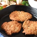 Cooked pork steaks in a cast iron pan.