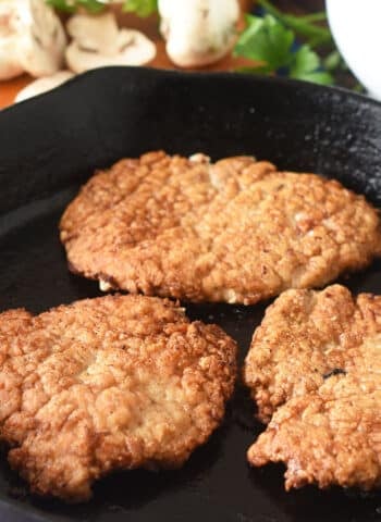 Cooked pork steaks in a cast iron pan.